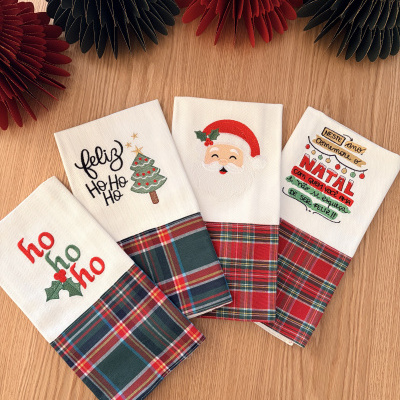 Toalhas de Natal com bordados e padrão xadrez sobre mesa de madeira clara