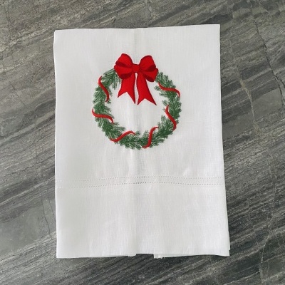 Guardanapo branco com bordado de coroa de Natal com laço vermelho