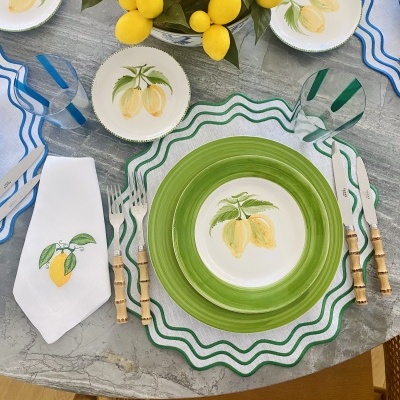 Conjunto de loiça com tema limão e talheres de bambu sobre mesa de mármore