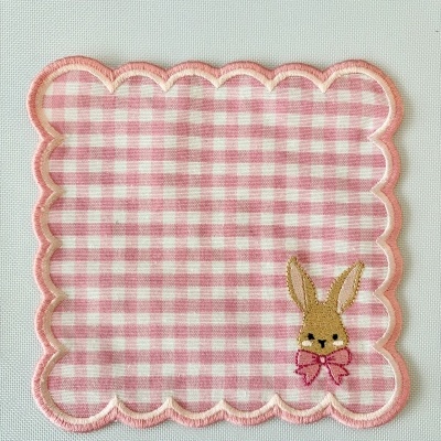Toalhinha quadrada com padrão rosa e branco e coelho bordado