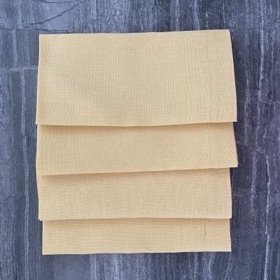 Panos de cozinha amarelos empilhados sobre superfície cinza texturada