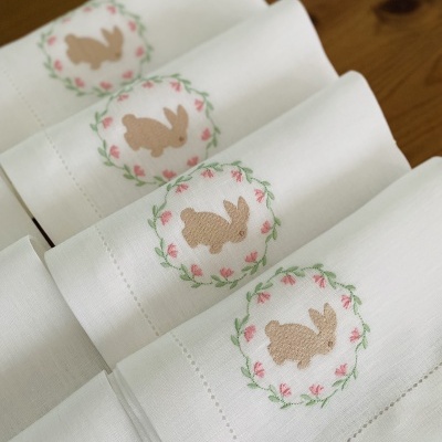 Quatro toalhas brancas com bordado de coelhos em coroa floral rosa e verde