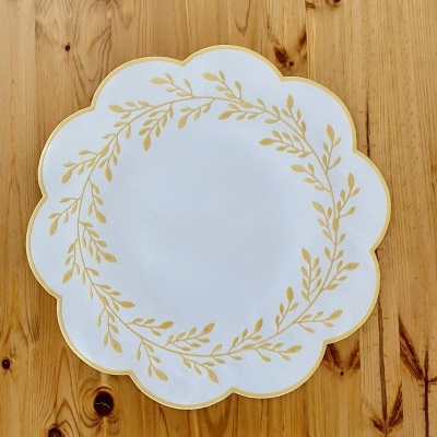 Prato branco com padrão dourado em mesa de madeira