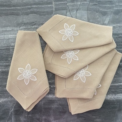 Guarda-napos de tecido bege com bordado floral branco