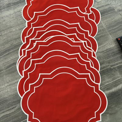 Conjunto de toalhetes de mesa vermelhos com bordas brancas sobre mesa cinzenta.