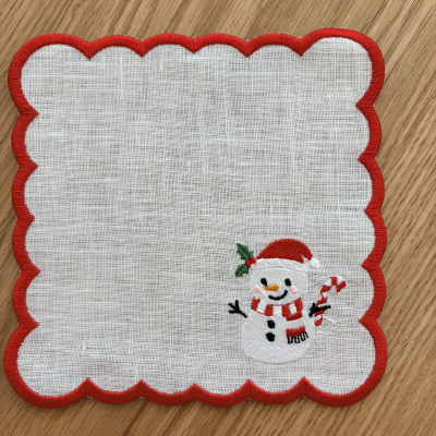 Pano branco com bordas vermelhas e boneco de neve bordado no canto