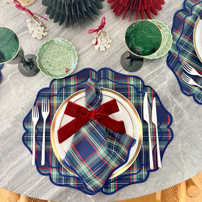Mesa de jantar com decoração e louça para Natal em padrão xadrez e verde com dourado