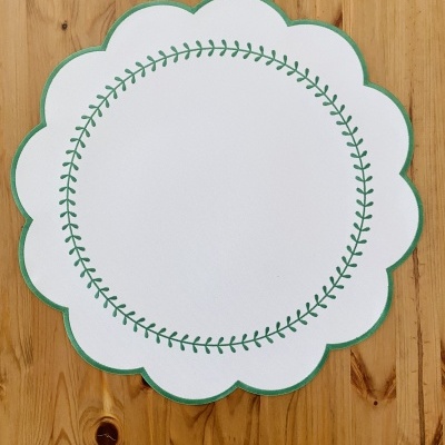 Guardanapo ou toalhete branco com padrão verde sobre mesa de madeira