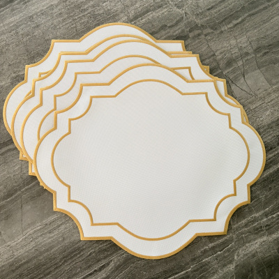Conjunto de etiquetas em papel branco com bordas douradas sobre superfície de pedra cinza