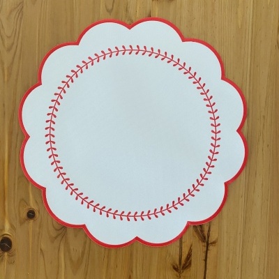 Guardanapo branco com padrão vermelho em superfície de madeira