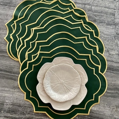 Conjunto de bases de mesa verdes com borda dourada e pratos decorativos creme em forma de flor