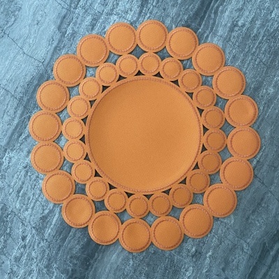 Tapete redondo laranja com círculos concêntricos sobre piso de mármore cinzento