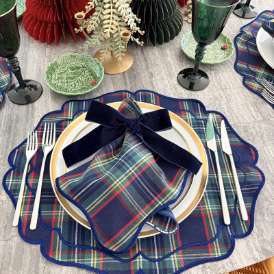 Mesa posta com acessórios de tecido xadrez azul e decoração natalícia