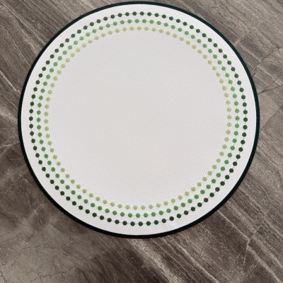 Tapete redondo branco com pontos verdes em piso de pedra cinzenta