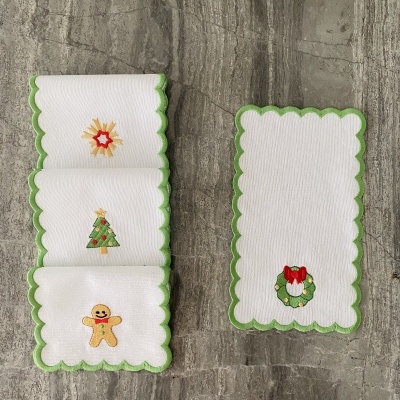 Guardanapos brancos com bordas verdes e bordados de Natal