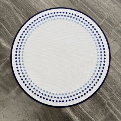 Tapete redondo branco com padrão de pontos azuis sobre chão de mármore cinza