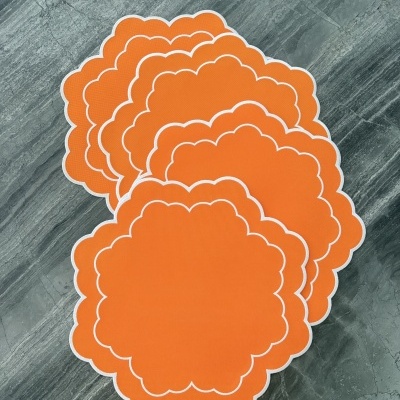 Bases de copos laranja com bordas brancas em formato nuvem sobre pedra cinzenta.