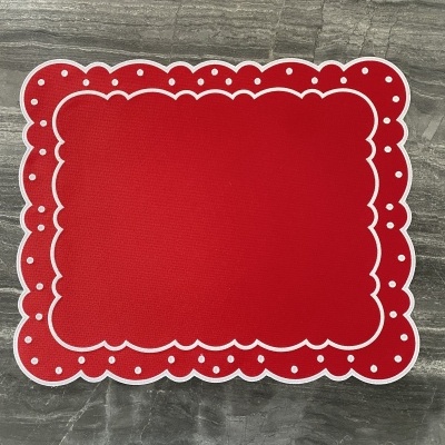 Toalhete vermelho com padrão branco e pontos brancos sobre superfície cinza