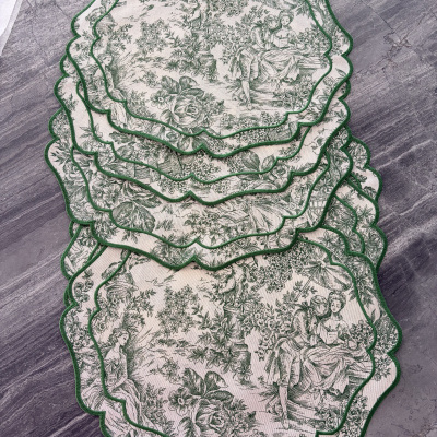 Guardanapos de tecido vintage com padrão verde e branco e bordas onduladas verdes numa mesa cinza.