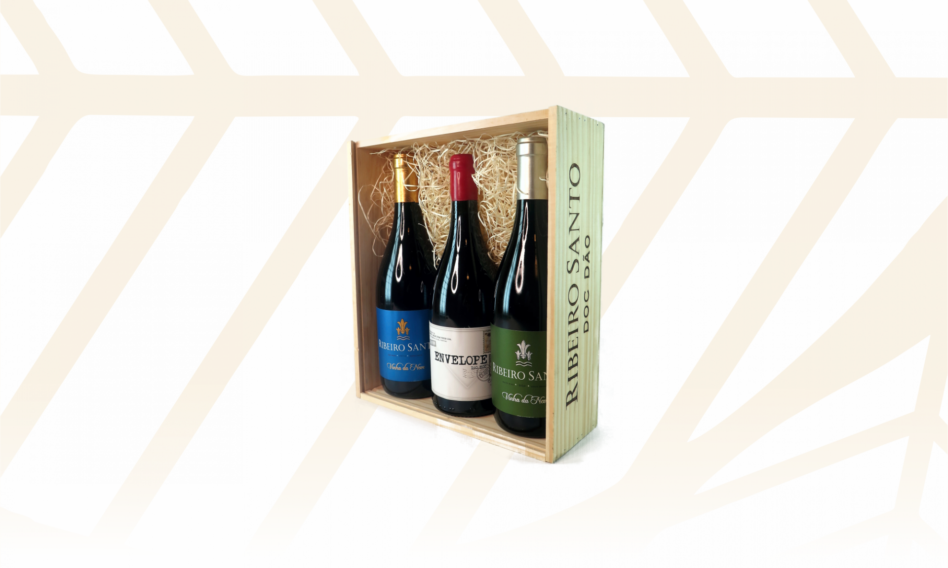 Caixa de madeira com três garrafas de vinho tinto e palha decorativa