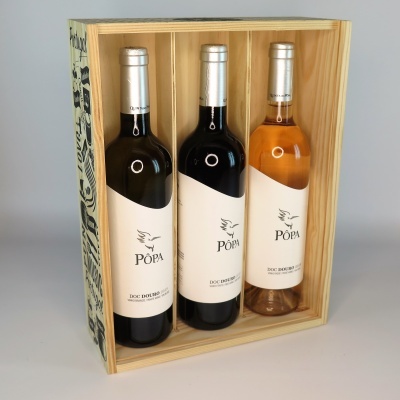 Três garrafas de vinho PÓPA numa caixa de madeira