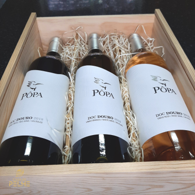 Caixa de madeira com três garrafas de vinho PÓPA com rótulos brancos, vinho tinto, branco e rosé DOC DOURO 2018