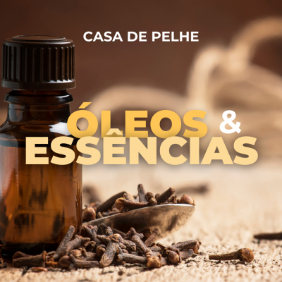 Frasco de óleo essencial com cravos-da-índia sobre madeira