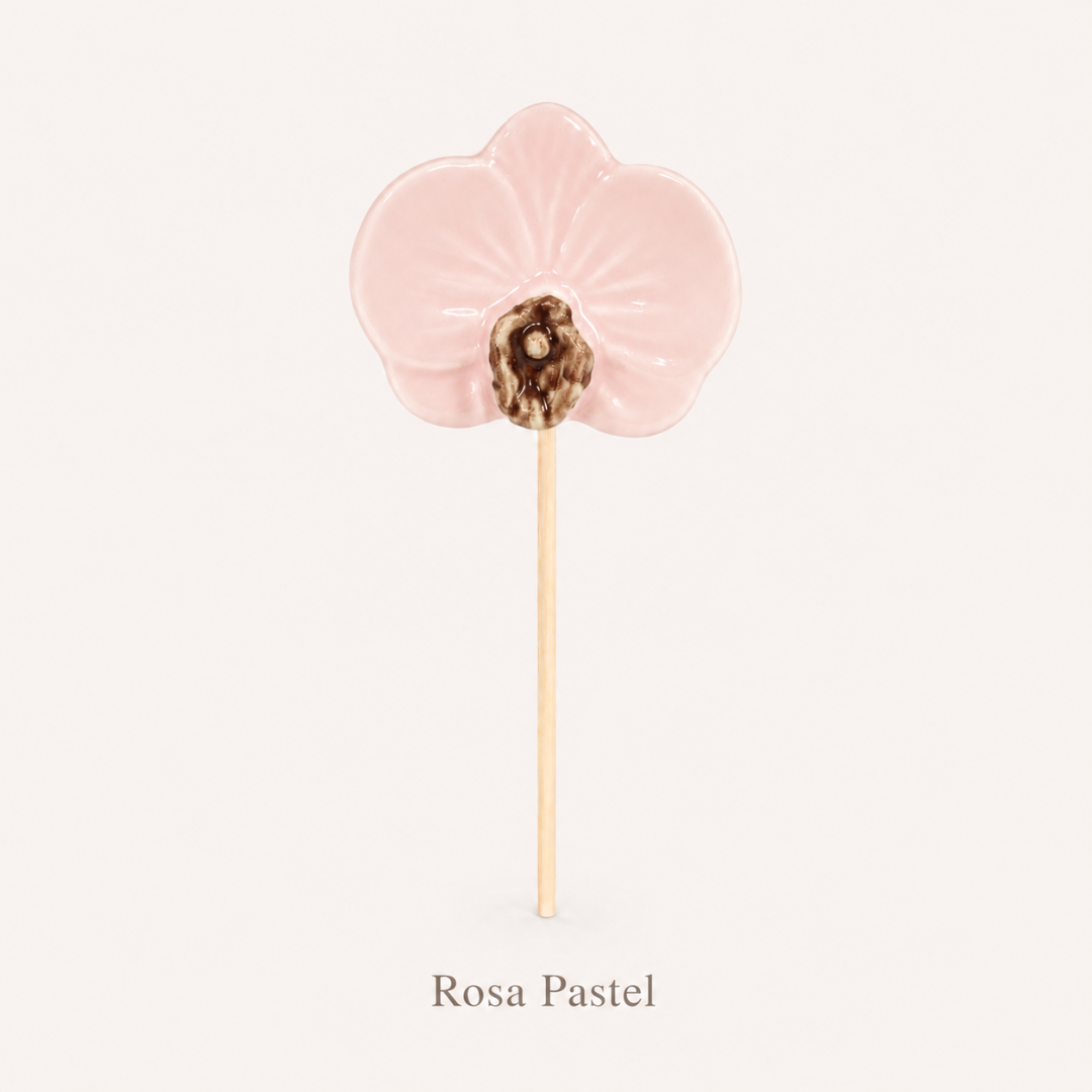 Pirulito cor de rosa pastel em forma de flor com parte marrom no centro.