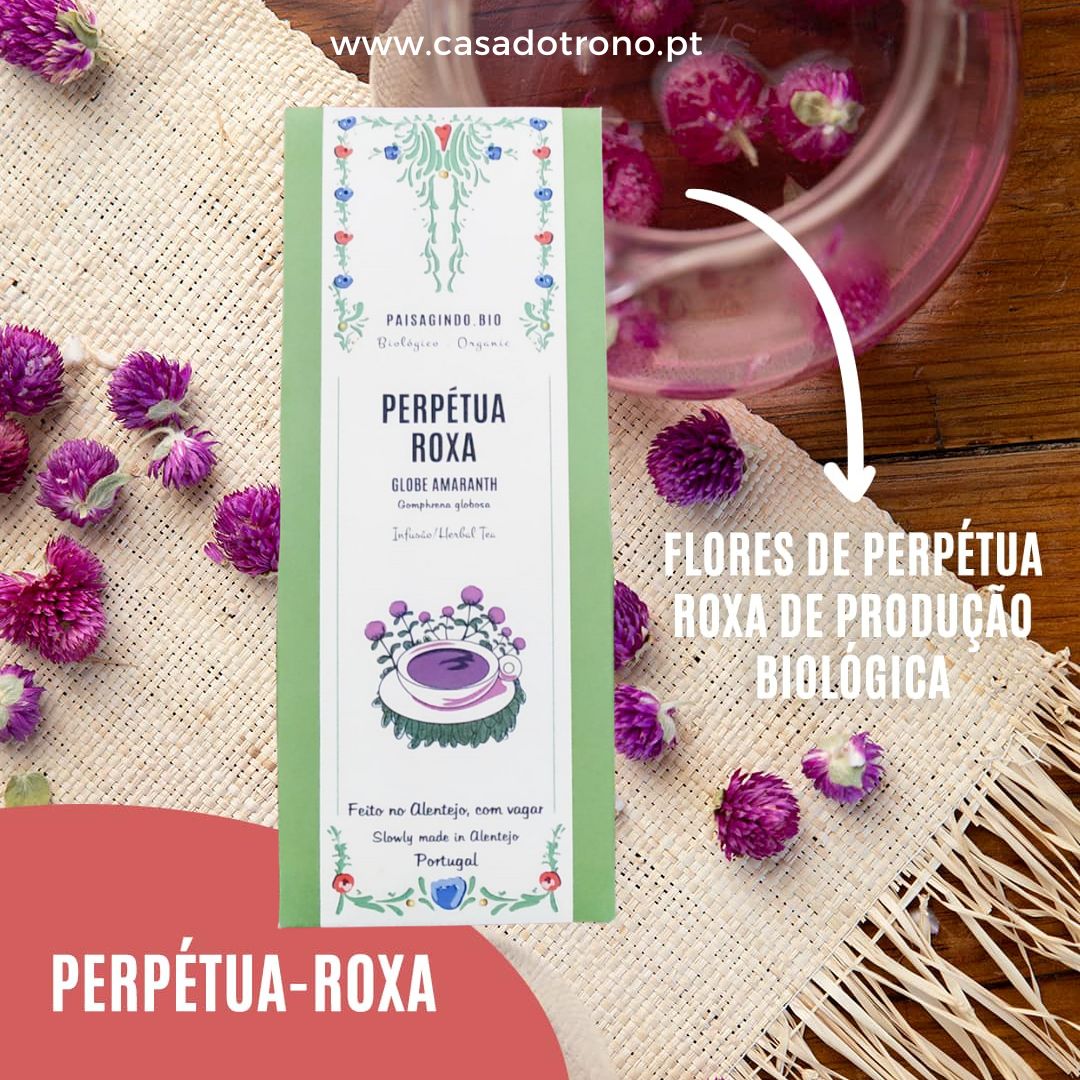 Embalagem de chá perpétua roxa com flores e chá numa mesa de madeira