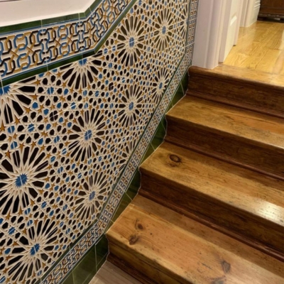 Escada de madeira com azulejos decorativos coloridos na parede