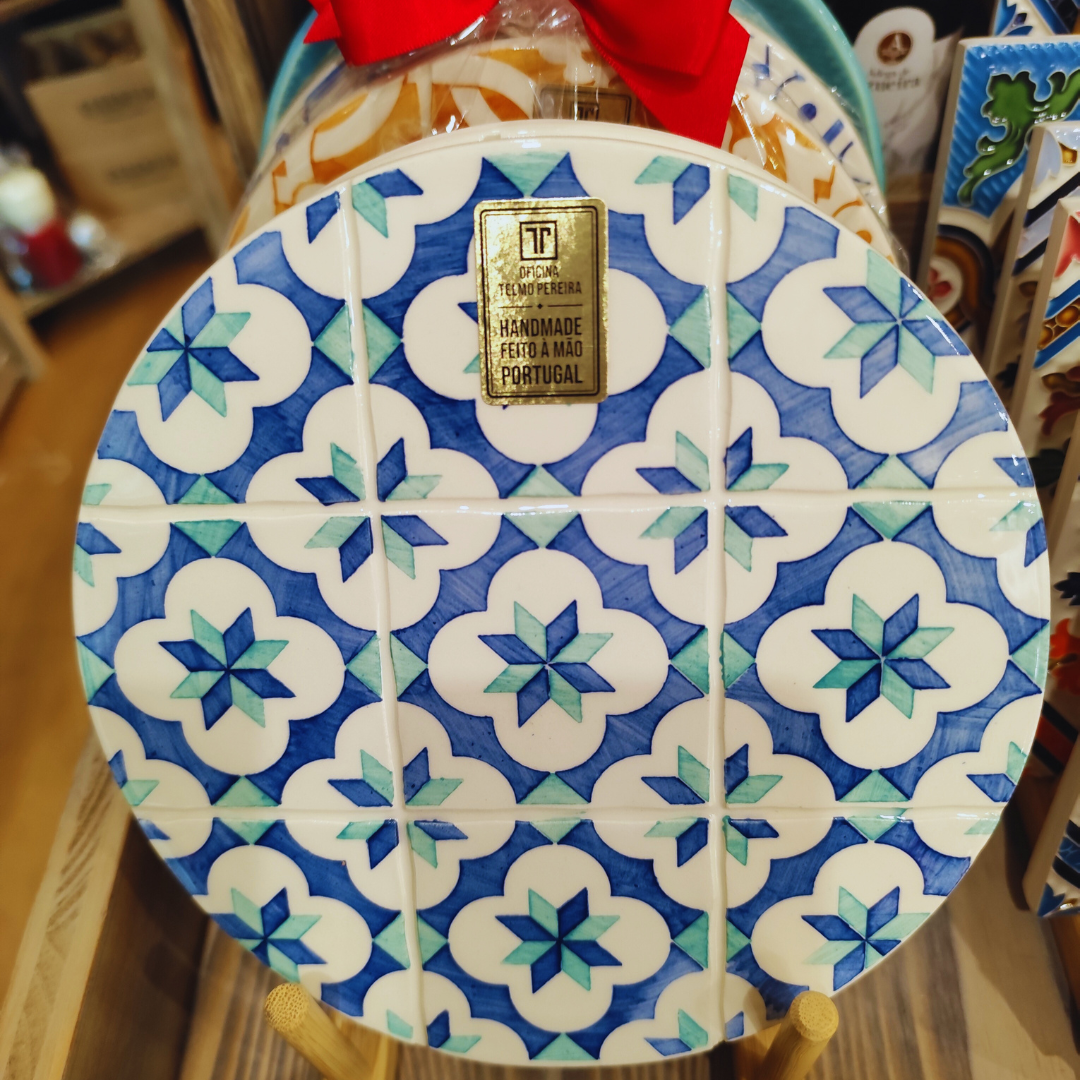 Prato de cerâmica com padrão de azulejos azul, branco e verde, etiqueta com texto handmade Portugal