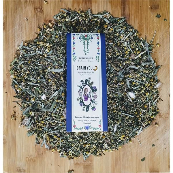 Mistura de ervas e flores secas com rótulo branco azul com texto e ilustração no centro sobre madeira