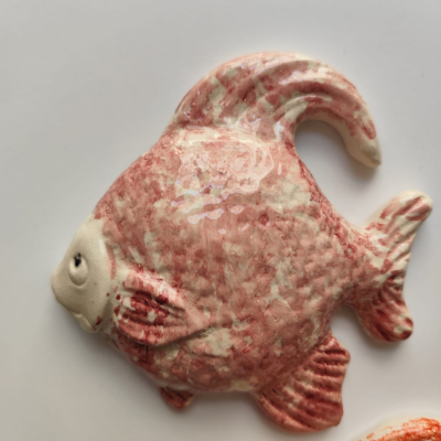 Peixe decorativo em cerâmica vermelha e branca com textura brilhante
