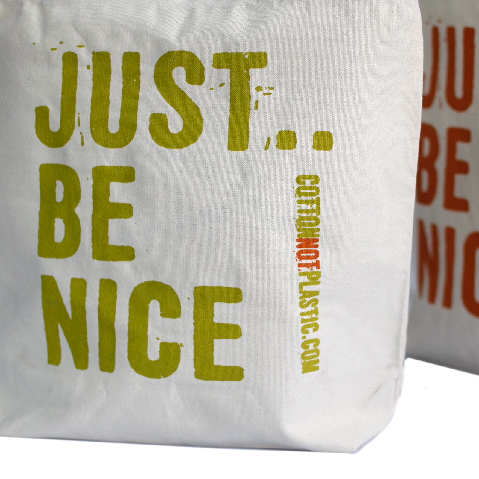 Bolsa de tecido branca com texto JUST.. BE NICE em verde-oliva e URL em amarelo e vermelho