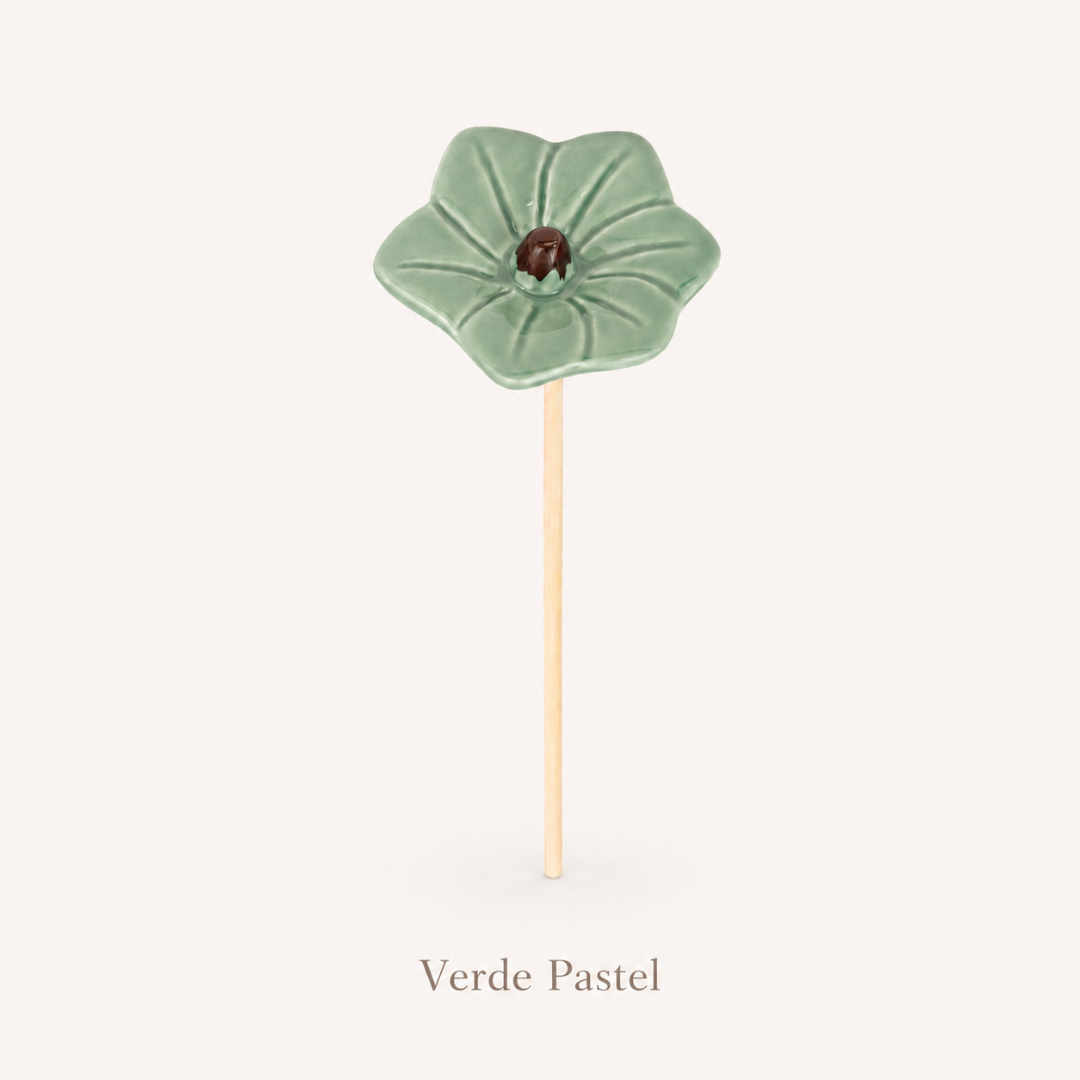 Pendente cerâmica em forma de flor verde pastel com pau de madeira.