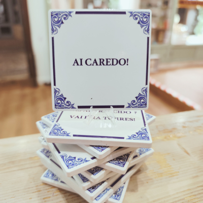 Azulejos decorativos brancos com moldura azul e texto 'AI CAREDO!'