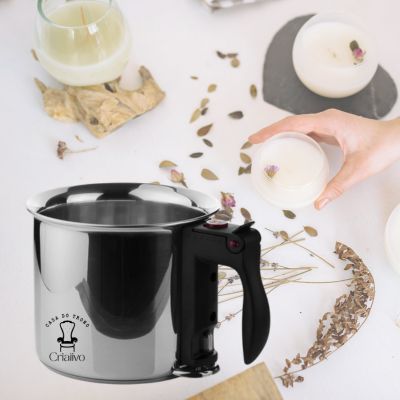 Vasilha prateada com cabo preto e velas com flores secas