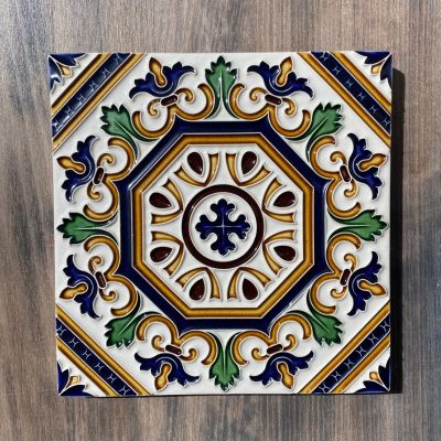 Azulejo cerâmico decorativo com padrão colorido octogonal sobre fundo de madeira