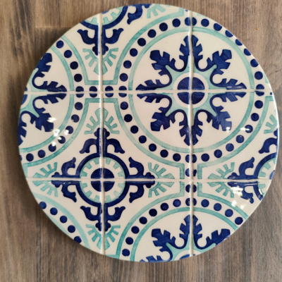 Prato cerâmico redondo com padrão azul e branco sobre mesa de madeira