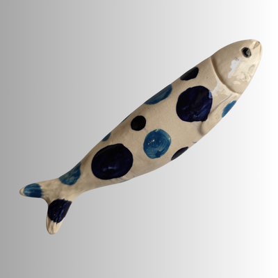 Figura decorativa em cerâmica em forma de peixe com bolinhas azuis e pretas.