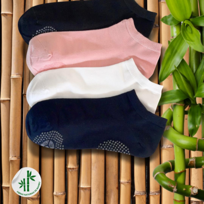 Conjunto de quatro pares de meias coloridas sobre bambu com planta verde