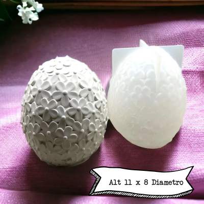 Dois ovos decorativos, um branco com flores e um translúcido sobre pano roxo