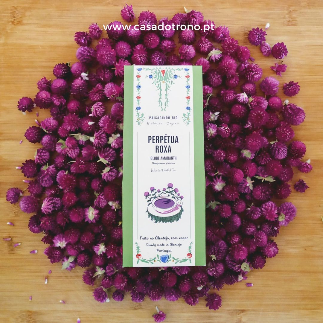 Caixa branca de produto sobre pétalas roxas em fundo de madeira clara