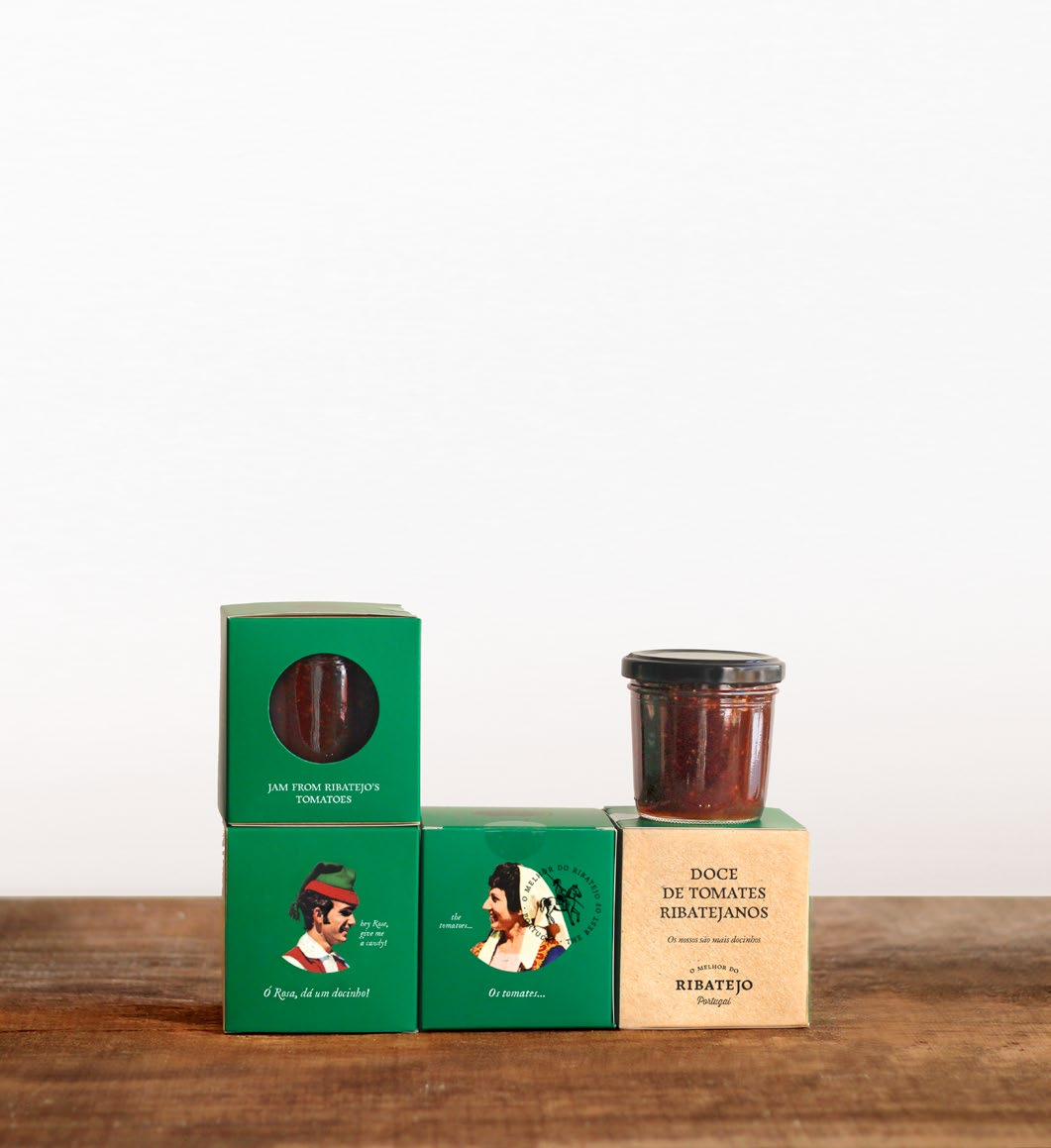 Embalagens verdes e creme com frasco de doce de tomate em cima sobre mesa de madeira