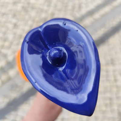 Flor artificial azul escura com textura brilhante segurada na mão