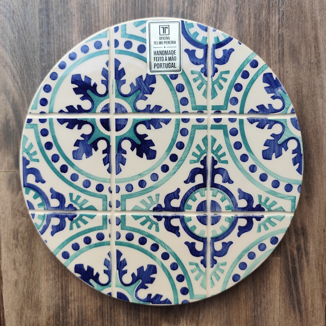 Prato redondo azul e verde com padrão de azulejos e etiqueta artesanal