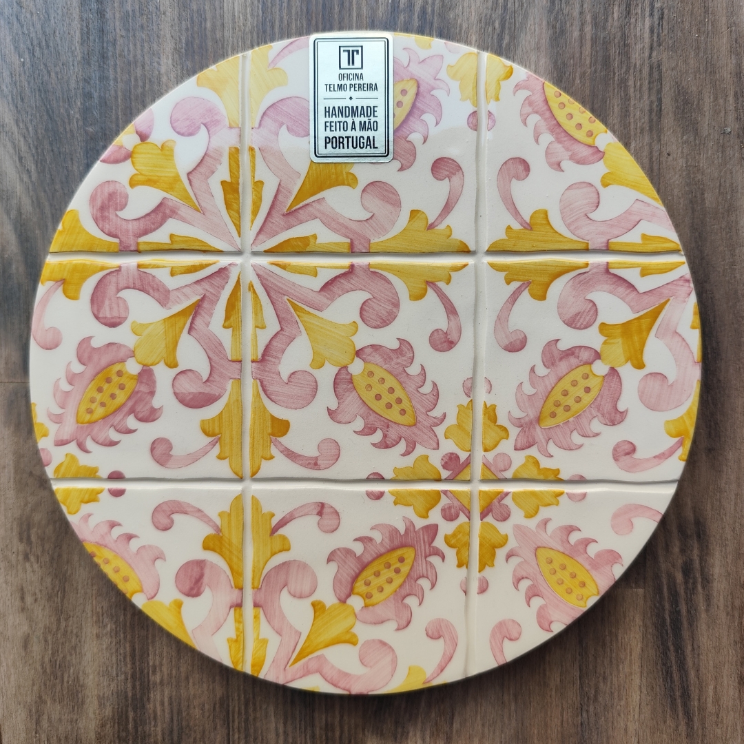 Placa decorativa circular de azulejos com padrão floral amarelo e rosa