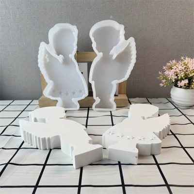 Formas em silicone branco de anjos com estrelas, em superfície quadriculada, com vaso de flores ao fundo