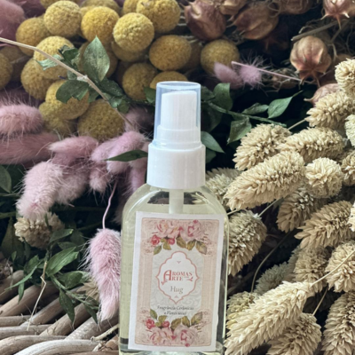 Frasco de spray com rótulo floral rodeado por flores secas