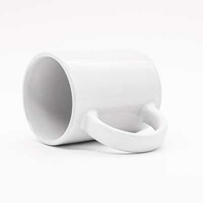 Caneca de cerâmica branca simples deitada ao lado